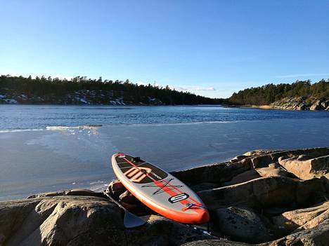 Helsinkiläinen Jan-Erik Luther on juuri suppaillut jään poikki rantaan. Puhallettava suppilauta on miehen vakiovaruste liikuttaessa saaristossa kelirikkoaikaan.