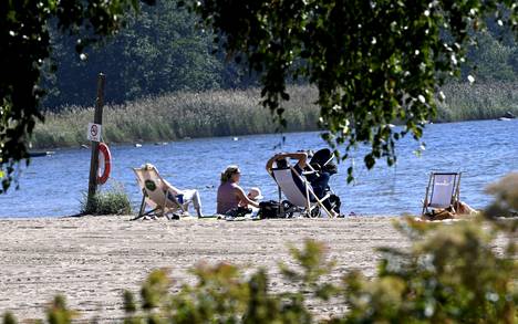 Ihmisiä rannalla Lauttasaaressa Helsingissä lämpimänä kesäpäivänä 12. elokuuta.