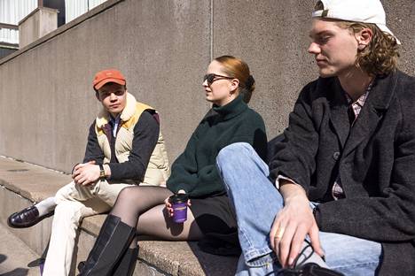 Joonas Virkki (vas.), Wilma Parkkari ja Eero Kuokka nauttivat auringosta istuen Porthanian edessä olevalla betonipenkillä. 
