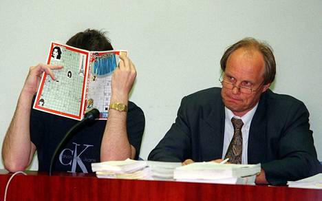 Raimo Tienhaara peitti kasvonsa kameroilta Helsingin hovioikeudessa vuonna 1998. Vieressä hänen tuolloin oikeusavustajansa Risto Kyytinen.