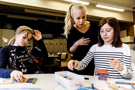 Neljäsluokkalaiset Elisa Tuppurainen (vas.) ja Miisa Leinonen opettelivat murtolukuja värisauvojen avulla Oulun normaalikoulussa. Harjoittelija Emma Juntunen opasti.