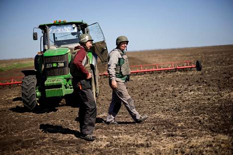 Ukrainalaiset maanviljelijät olivat pukeutuneet suojavarusteisiin työskennellessään pellolla Zaporižžjan lähistöllä 26. huhtikuuta.