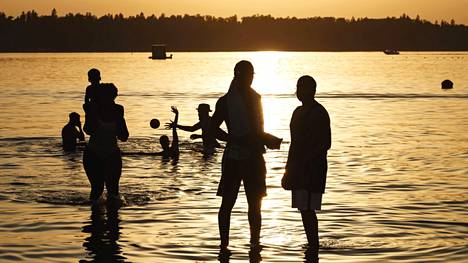 Helsinkiläiset nauttivat lämpimistä kesäöistä jo juhannusviikon alussa Hietaniemen uimarannalla. 
