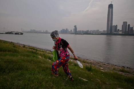 Nainen kasvomaskissa kävelee Jangtsejoen rantapenkalla Wuhanissa Kiinassa 28. toukokuuta.