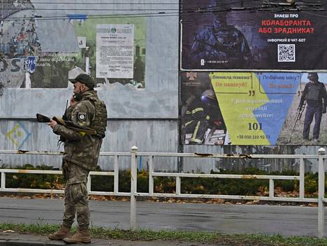 Ukrainalaispoliisi puhui puhelimeen Hersonissa 8. joulukuuta. Juliste kehottaa ilmoittamaan ihmisistä, jotka ovat tehneet yhteistyötä Venäjän joukkojen kanssa.