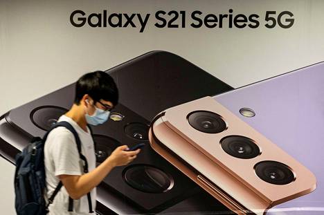 Ohikulkija Samsungin 5g-puhelimia mainostavan julisteen edustalla Hongkongissa keväällä 2021.