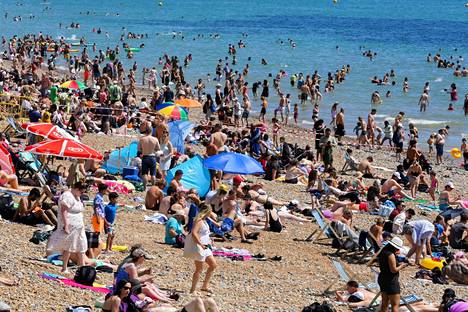 Auringonottajat kansoittivat sunnuntaina uimarannan Brightonissa Britanniassa.