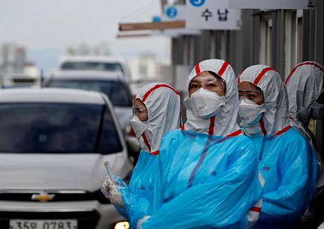 Suojavarusteisiin pukeutuneita koronatestin ottajia autolla tuleville asiakkaille yliopistollisessa sairaalassa Daegussa maaliskuun alussa.