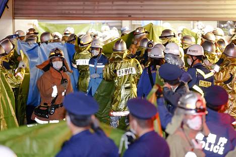 Pelastustyöntekijöitä iskun tapahtumapaikalla Tokiossa sunnuntai-iltana.