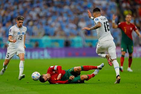 Portugalin Cristiano Ronaldo makasi kentällä kamppailtuaan pallosta Uruguayn Mathias Oliveran kanssa.