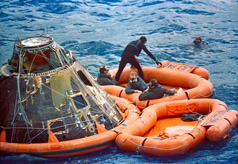 Apollo 14 -lennon miehistö odottaa kumiveneessä, että helikopteri nostaa kolmikon Yhdysvaltain laivaston alukselle helmikuussa 1971. 