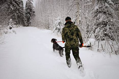 Otso Qvick tarpoo lumessa Pekko-koiran kanssa. Metsästys on Qvickin tärkein harrastus ja yksi syy siihen, miksi Pielavedellä on hyvä asua.