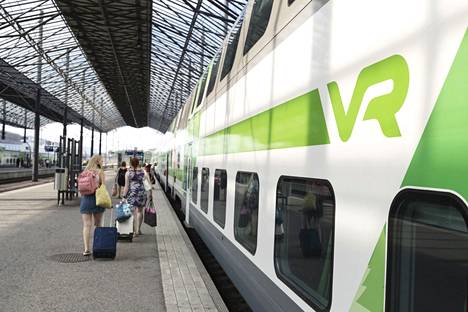 Matkustajia ja VR:n logo kaukoliikenteen junassa Helsingin päärautatieasemalla 7. heinäkuuta 2021.