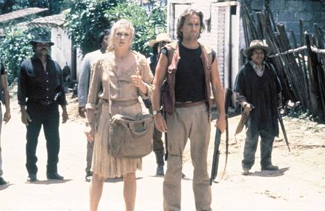 Joan Wilder (Kathleen Turner) ja Jack Colton (Michael Douglas) joutuvat kovaan paikkaan elokuvassa Vihreän timantin metsästys (1984). 