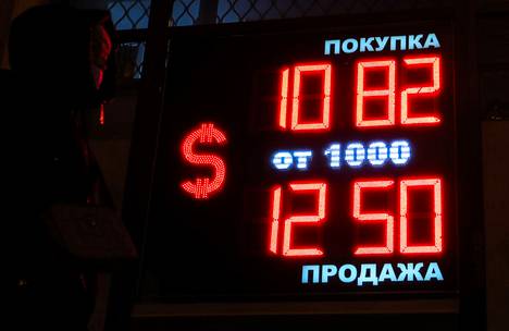 Venäjä sallii väliaikaisesti, että venäläiset yhtiöt ja yksityishenkilöt voivat maksaa velkojaan tietyille ulkomaisille velkojille ruplilla. Ohikulkija käveli rahanvaihtotoimiston ohi Pietarissa 4. maaliskuuta.