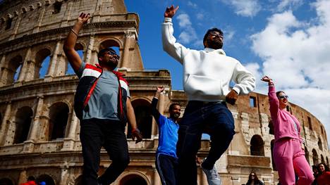 Joukko turisteja tanssahteli Roomassa Colosseumin edustalla huhtikuussa.