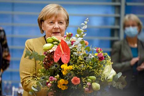 Luopuva liittokansleri Angela Merkel sai kukkia ennen Saksan hallituksen kokousta 24. marraskuuta.