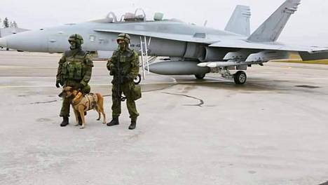 Raven-joukot suojelevat Ilmavoimien lentokoneita. Taustalla Hornet-hävittäjä.