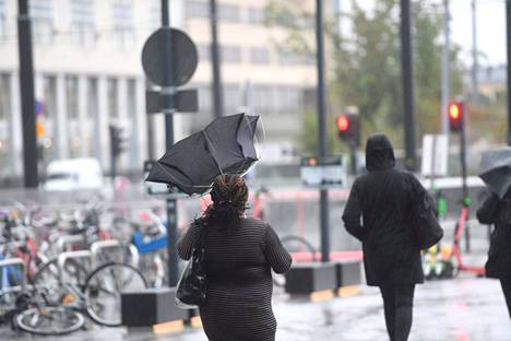 Loppuviikon sää on sateinen ja tuulinen. Jalankulkija sateenvarjon kanssa Helsingissä keskiviikkona 25. elokuuta 2021.
