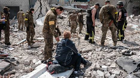 Sotilaat ja pelastusviranomaiset tutkivat pommituksessa tuhoutuneen koulun raunioita itäukrainalaisessa Sydorovessa tiistiana.