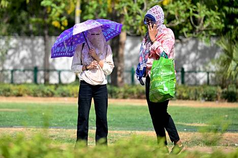 Women protected themselves from the heat with scarves in New Delhi.