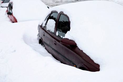 The cars were buried under the snow in Pihlajamäki, Helsinki, on Monday.