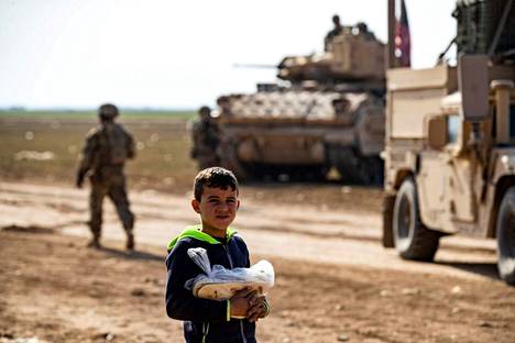 Poika kantoi leipää amerikkalaissotilaiden edessä Tal Hamisin lähellä Kaakkois-Syyriassa perjantaina.