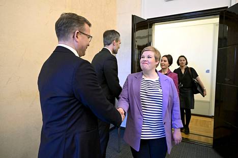 Kokoomuksen Petteri Orpo ja keskustan Annika Saarikko kättelivät eduskunnassa pidetyssä tilaisuudessa perjantaina.