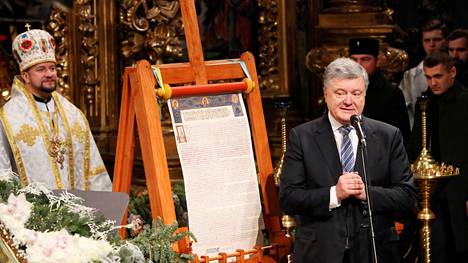 Presidentti Petro Porošenko puhui Kiovassa Pyhän Sofian katedraalissa vierellään asiakirja, jolla Ukrainan kirkko sai itsenäisen aseman ja siirtyi Moskovan alaisuudesta Konstantinopolin alaisuuteen.