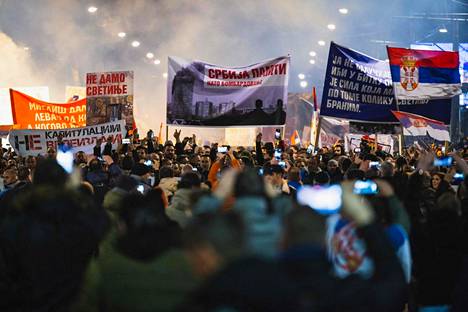Ihmiset marssivat perjantaina Belgradissa. 