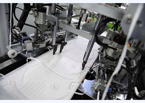 Kuvassa on automaattinen hengityssuojainten valmistuslinja Lifa Airin tehtaalla Etelä-Kiinassa. Suomalaista maskituotantoa ei ole päästy kuvaamaan.