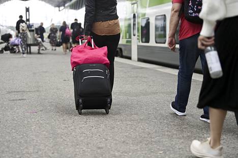 Juhannuksen viettoon lähteviä matkustajia Helsingin rautatieasemalla kesäkuussa.