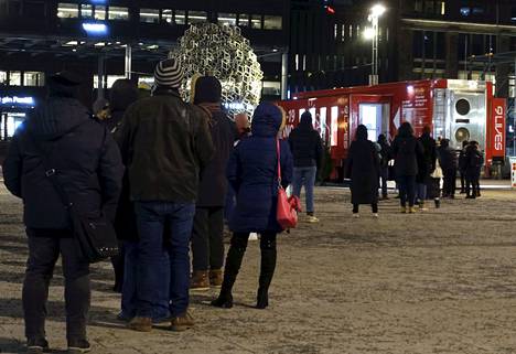 Pitkä jono yksityisen 9Lives-yrityksen koronatestipaikkaan Narinkkatorilla Helsingissä alkuillasta tiistaina 21. joulukuuta 2021.