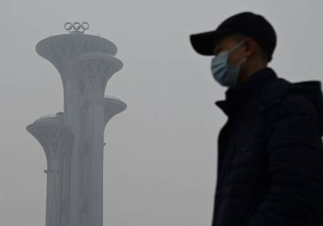 Mies käveli Pekingin olympiapuistossa savusumuisena maanantaina. 