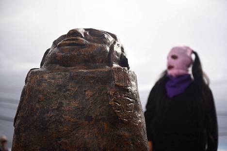 A woman waited for the start of a demonstration next to the fertility symbol Illa in Bolivia on Women's Day 2024.