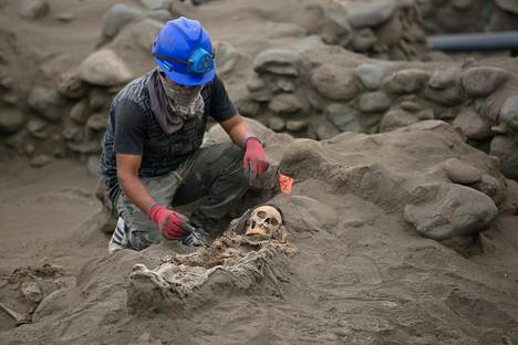 Arkeologi kaivoi luurankoa esiin joukkohaudasta Pampa La Cruzissa Perussa torstaina.