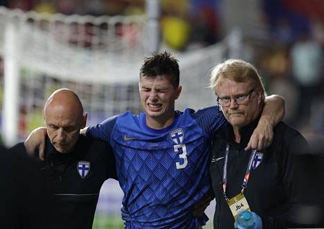 Huuhkajien huoltajat auttoivat loukkaantuneen Daniel O'Shaughnessyn pois kentältä Romaniaa vastaan pelatussa ottelussa.