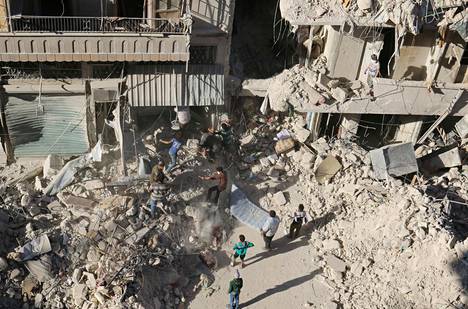 Ihmiset kaivoivat mahdollisia eloonjääneitä raunioista maanantaina Aleppon Tariq al-Babin kaupunginosassa ilmapommitusten jälkeen.