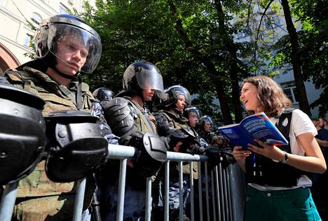 Olga Misik luki Venäjän perustuslakia 27. heinäkuuta 2019 mellakkapoliisirivistön edessä Moskovan keskustassa.