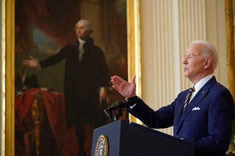 Presidentti Joe Biden puhumassa toisen virkavuotensa avanneessa lehdistötilaisuudessa  Valkoisessa talossa keskiviikkona. Taustalla maalaus George Washingtonista.