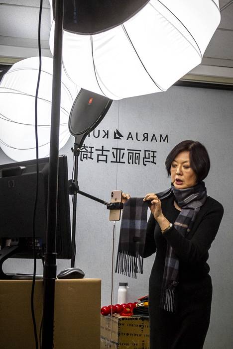 Caroline Xue näyttää kännykän kameralle, millaista materiaalia huivi on.