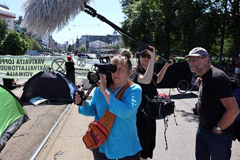 Miten korjata maailma -elokuvan kuvausryhmä kuvaamassa Elokapinan mielenosoitusta Mannerheimintiellä kesäkuussa 2021: kuvaaja Marita Hällfors, äänittäjä Lou Strömberg ja ohjaaja Jouko Aaltonen.