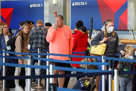 Matkustajia maskien kanssa ja ilman niitä Bostonin lentokentällä tiistaina. Delta ja monet muut lentoyhtiöt luopuivat maskipakosta tämän viikon alussa sen jälkeen, kun tuomari kumosi maanlaajuisen maskipakon julkisessa liikenteessä. 