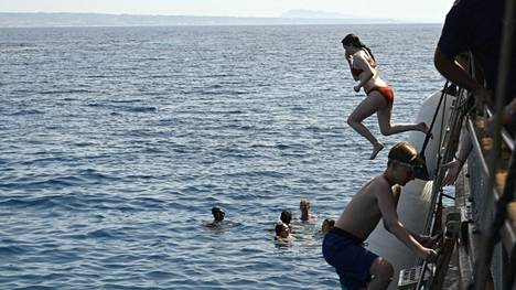 Turisteja vilvoittelemassa Kreikassa kesäkuussa 2024. Kreikan eteläosiin ennustetaan alkavalla viikolla jopa yli 40 asteen helteitä.