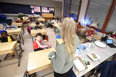 Opettaja ohjaa ekaluokkalaisia Itäkeskuksen peruskoulussa.