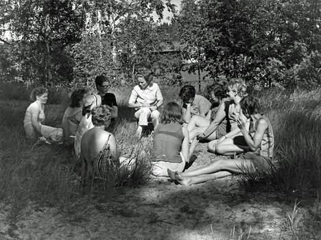 Vapaamuotoista ”ryhmäterapiaa” nurmikolla vanhan kansakoulun jo villiintyneessä puutarhassa.