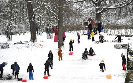 Ensi viikolla Suomessa saatetaan kokea vuoden ensimmäinen lumimyräkkä. Ulkoilijoita mäenlaskussa Toukolassa Helsingissä 4. tammikuuta 2021.