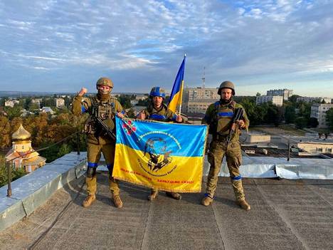 Ukrainalaissotilaat poseerasivat maan lipun kanssa kattotasanteella Kupjanskissa lauantaina.