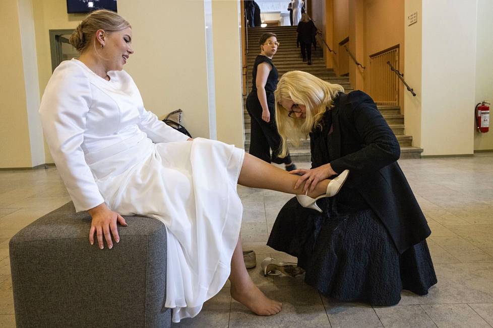 Kasvatuspsykologian professori Kirsti Lonka polvistui tyttärensä maisteri Milla Lonkan eteen ja auttoi kengän tämän jalkaan.