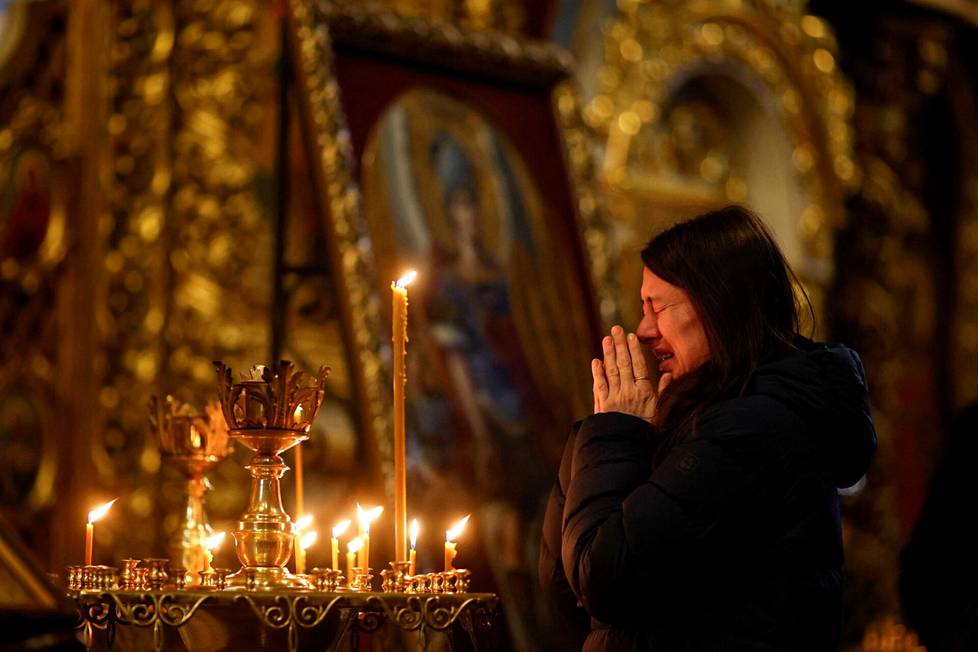 Nainen itkee sunnuntain jumalanpalveluksessa Pyhän Andreaksen kirkossa Kiovassa.